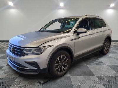 un SUV Volkswagen blanc garé sur un sol en carrelage à damier