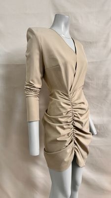 the mannequin is wearing a tan dress with long sleeves