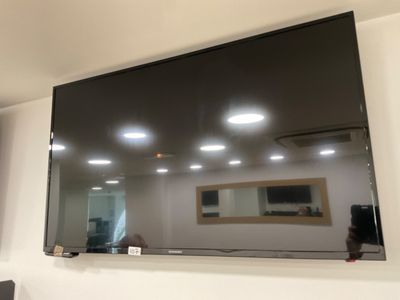 a flat screen tv mounted on the wall above a mirror
