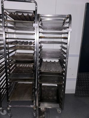 two racks with trays of food on them in a kitchen