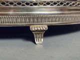 un plateau en argent orné d'une horloge, posé sur une table
