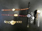 Plusieurs modèles de montres sont exposés sur un fond noir