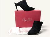 une paire de chaussures à talons hauts noires posée sur une boîte rose