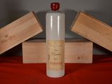 a bottle of alcohol sitting on a table next to two wooden boxes