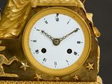 a gold clock with a statue on top of it