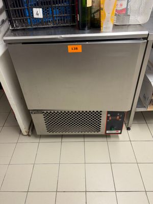 une photo d'un réfrigérateur dans une cuisine, avec un panier posé dessus
