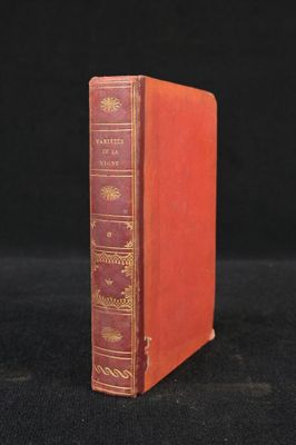 a red book sitting on top of a black surface