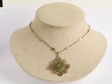 collier en or avec un pendentif vert autour du cou d'un mannequin
