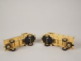 pair of yellow toy cars sitting on top of a white surface