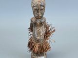 un gros plan sur une figurine représentant une personne portant une jupe en paille