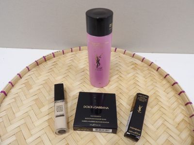 un flacon de liquide, un mascara et une brosse à mascara posés sur un plateau