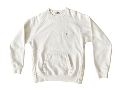 the sweatshirt is white and has a pocket on the front