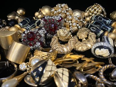 un tas de bijoux en or et en argent posés sur une surface noire