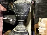 a black vase sitting on top of a stack of boxes