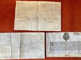 two old papers on a table with a red cloth