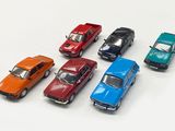 several toy cars are lined up in a row on a white surface