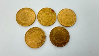quatre pièces d'or superposées sur une surface blanche