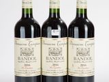 trois bouteilles de vin rouge posées l'une à côté de l'autre sur une surface blanche