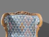 a blue and gold chair with a floral pattern on the back of it