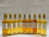 six bottles of wine are lined up in a row on a white surface