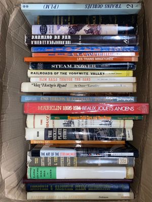 many books in a cardboard box on the floor