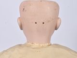 a small doll with a yellow dress on it ' s head