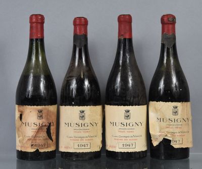 trois bouteilles de vin sont alignées sur une table en verre