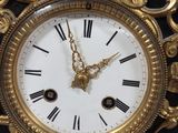 a gold clock with black and white roman numerals on it