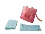 un sac rose et un sac bleu posés sur une surface blanche