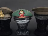 three military hats sitting on top of each other on top of a mannequin head