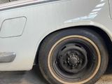 a close up of a flat tire on a white car