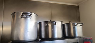trois casseroles posées sur la cuisinière dans la cuisine