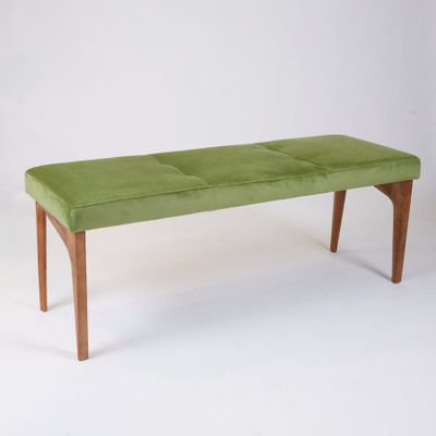 a green bench that is sitting on a white surface