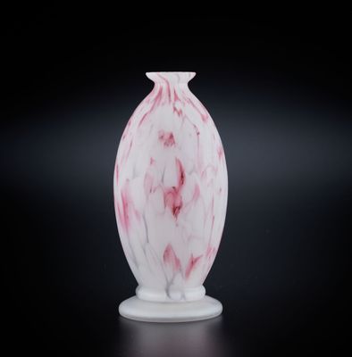 un vase blanc orné d'un tourbillon rose sur un fond noir