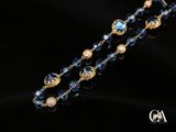 un gros plan d'un collier bleu et or sur fond noir