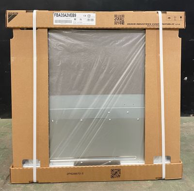 une boîte en carton posée par terre, contenant un ordinateur portable