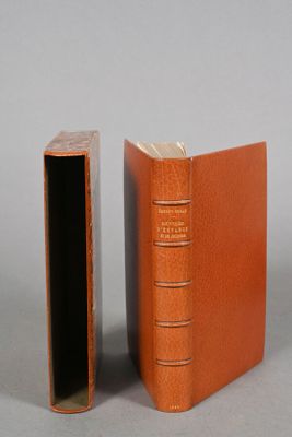 an orange book sitting next to a closed book on top of a table