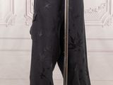 a mannequin mannequin in front of a white wall wearing black pants and a black top