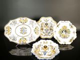 trois assiettes ornées de motifs dorés et bleus, posées sur une surface noire