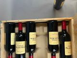 several bottles of wine are in a wooden box on a table