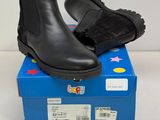 black leather ankle boots on top of a blue box on a white surface