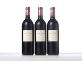 three bottles of wine are lined up on a table