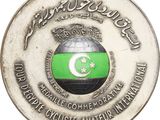 a silver coin with a green and white flag on it
