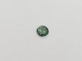 a green tourmaline gems on a white surface