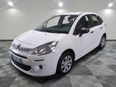 la petite voiture blanche est garée sur un carrelage à carreaux