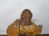 statue of a man with a book in his hand on a wooden table