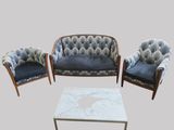 trois chaises, une table et un canapé dans une pièce