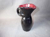 a black and red vase with a handle on a white background