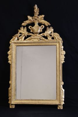 an ornate gold mirror with a bird on top of it