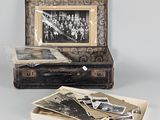 an old photo of a group of people sitting in a suitcase